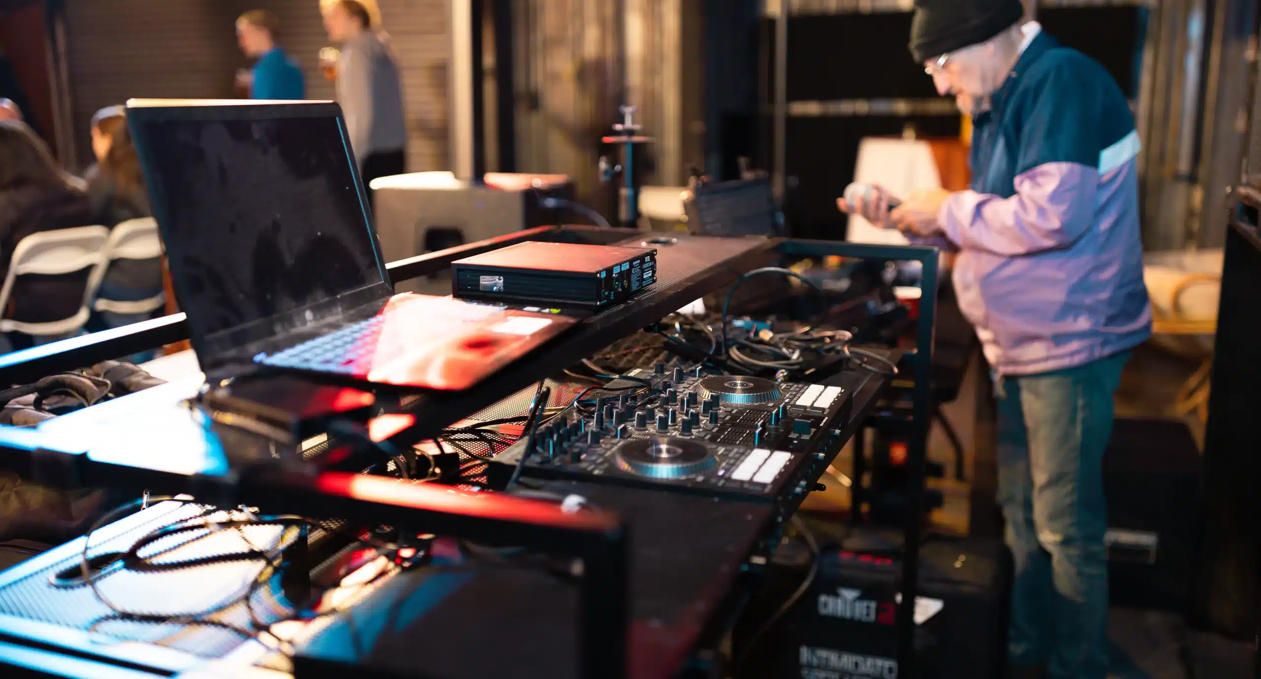 A DJ booth with a DJ in the background