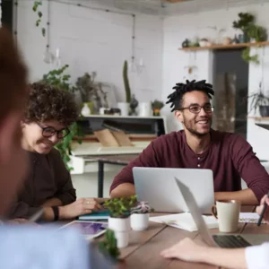 team of coworkers with laptops having a meeting at a table