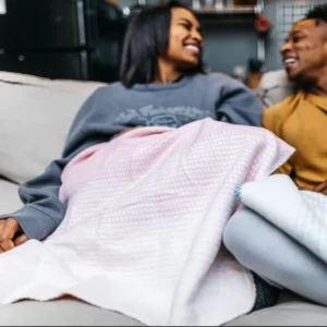 couple on couch with pink and white fleece blanket from thread talk