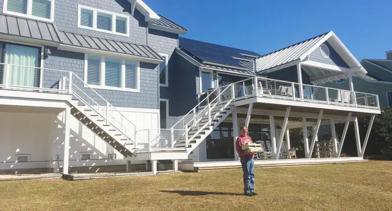 Solar referral basket winner from Southern Energy Management standing in front of his home solar system