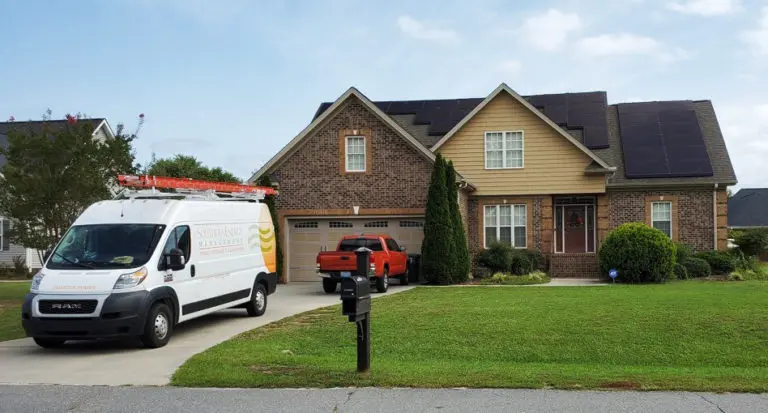 Home with solar on the roof and red truck in the driveway